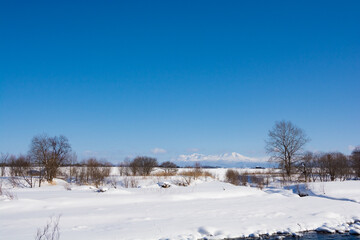 Fototapeta na wymiar 冬の河原と雪山と青空　大雪山 