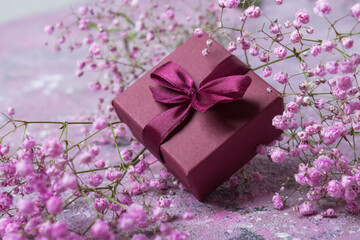 Gift box with burgundy color and gypsophile. Greeting card for Valentine's Day, anniversary, Mother's Day and birthday greetings, has a copy of the space