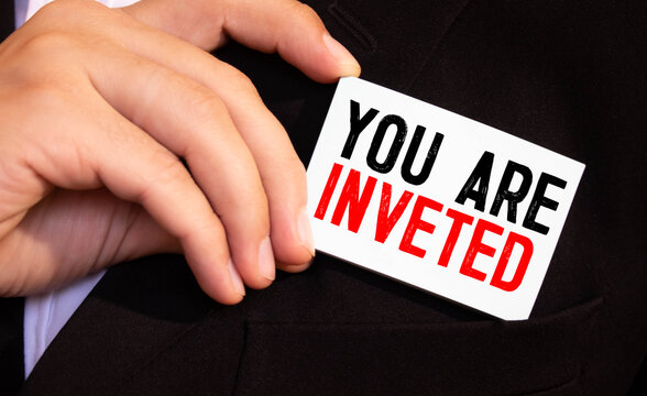 businessman holding a card with text YOU ARE INVETED