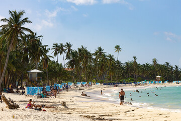 Fototapeta na wymiar caribbean sea beach with people enjoying the sun and water