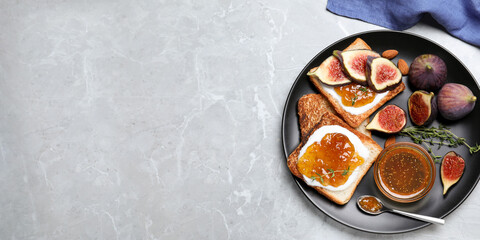 Tasty toasts with fig jam and cream cheese on grey marble table, flat lay. Space for text
