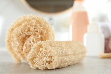 Fototapeta na wymiar Natural loofah sponges on table in bathroom, closeup