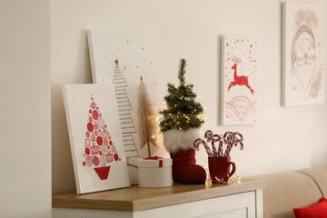 Beautiful Christmas pictures on chest of drawers indoors. Interior design