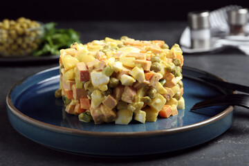 Delicious russian salad Olivier served on black table