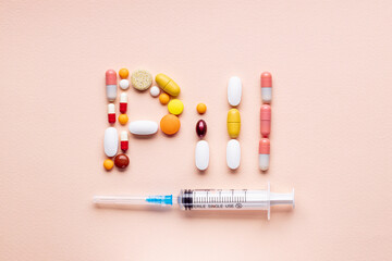 word pill made by assorted pills, tablets and capsules isolated on pink background. pharmacy industry concept. above view