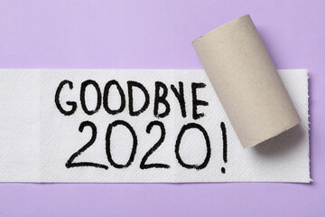Toilet paper with text Goodbye 2020 on lilac background, flat lay