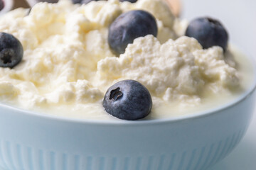 Whipped cheese with blueberries in a light blue ceramics bowl