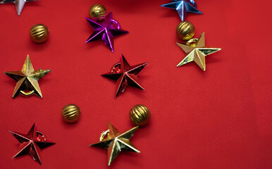 Christmas composition. Colorful stars and balls on a red background. Flat lay, top view, copy space