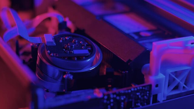 VHS tape inserted, played and ejected from inside a VCR with neon Lighting.
