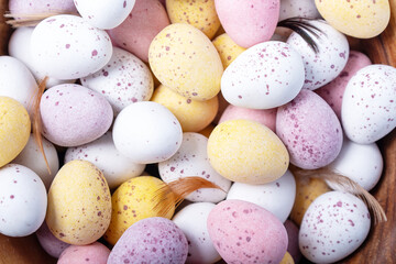 Easter holidays decoration. Easter sweets for children. Close-up. Top view. White yellow pink eggs for Easter treat.