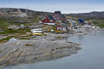 Colorful houses, drying fish, and sled dogs are a common sight in Rodebay (Oqatsut), set on the...