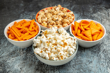 Fototapeta na wymiar front view different snacks for movie time on light-dark background cips rusks popcorn