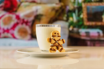 BDSM themed gingerbread cookies. fun looking cookies and a glass of milk. Sexy cookie with mouth ball and leather suit look designed in bsdm style.