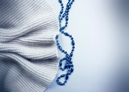 Gray knitted scarf and blue beads flat lay with fogging retro effect. copy space