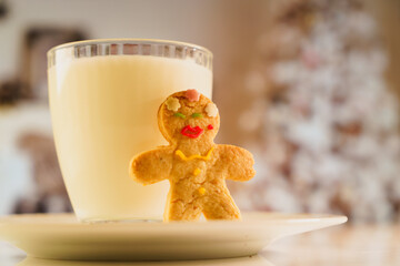 gingerbread and a glass of milk on a New Year and Christmas themed background with a Christmas tree...