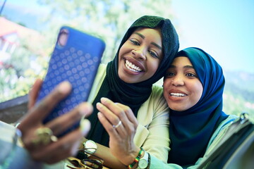 african female friends using smart phone together - Powered by Adobe