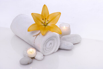 Composition with towel, spa stones and candles on white background

