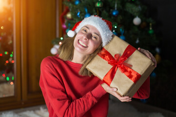 girl in red clothes unfold New year gifts. the concept of celebrating Christmas midnight. Holiday's decor boce, Christmas tree