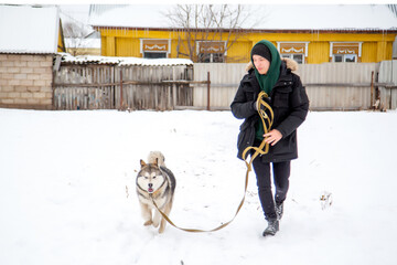 a man enjoys playing and training a dog outdoor in winter