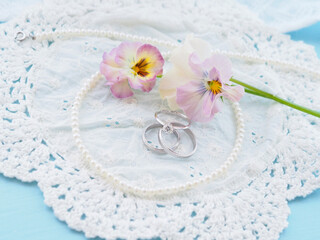 結婚指輪と真珠のネックレスとパンジー