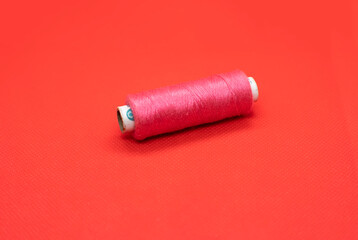 Bobbin of the thread on a red background