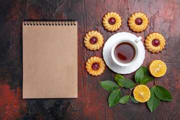 Obraz na płótnie Canvas top view cup of tea with little cookies on a dark background dessert biscuit sweet