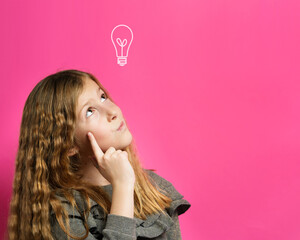 Idea concept - Young thoughtful caucasian girl eight years old looking up with finger on face contemplation in front of pink background - copy space