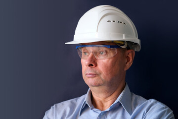 elderly male engineer, builder in protective helmet, glasses looking seriously, modern architecture concept, real estate purchase consultation