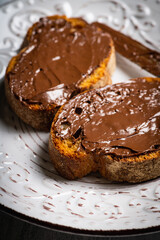 Slice of homemade bread with chocolate cream on the kitchen table for breakfast. Selective focus. Shallow depth of field.
