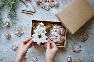 Christmas gingerbread in glaze in the form of symbol of the year bull and tree, Christmas symbols 2021, packed in a craft box for home delivery. new year food delivery concept.