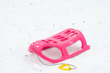 Pink and yellow plastic sleigh on for the children durrign winter