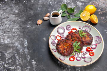 Fototapeta na wymiar top view delicious cutlets with onion rings on a grey background meat meal dish cuisine
