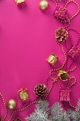 Christmas decorations with fir branches on a pink background with free space.