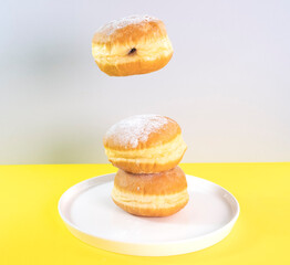 Donuts selection flying on yellow background. Various doughnuts isolated on colorful background