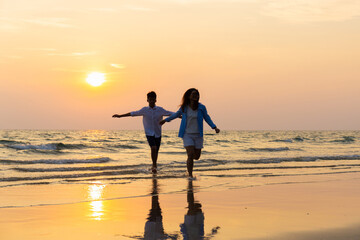 Fototapeta premium Mother and son running along a beach, Asian happy family parent with child boy running and having fun on the beach