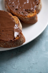 Slice of homemade bread with chocolate cream on the kitchen table for breakfast. Selective focus. Shallow depth of field.