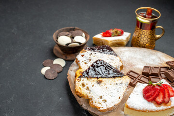 front view delicious cake slices with choco bars on dark background biscuit fruit sweet