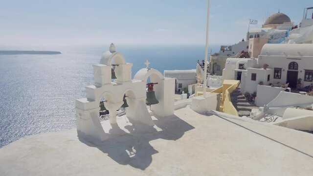 Bells of an orthodox church with a background of the Santorini caldera in Oia