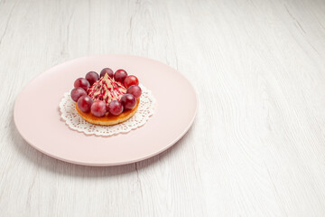 front view little cake with grapes inside plate on white floor fruit dessert cake