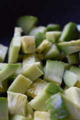 Chopped zucchini in black pan for vegetable wok