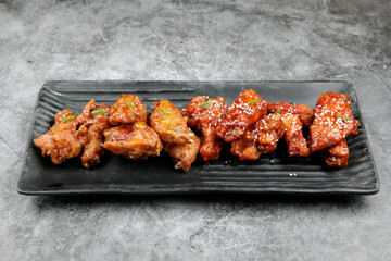 korean spicy fried chicken serve on a black long plate
