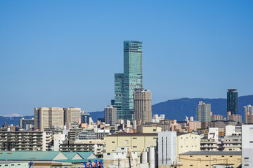 Fototapeta na wymiar 天王寺・阿倍野方面のビル群とタワーマンションと生駒山に立つ送信アンテナ