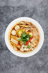 Chicken Tom Yum Noodle serve in white bowl