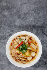 Chicken Tom Yum Noodle serve in white bowl