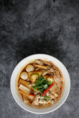 Chicken Tom Yum Noodle serve in white bowl