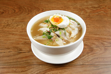 a bowl of chicken porridge with salted egg