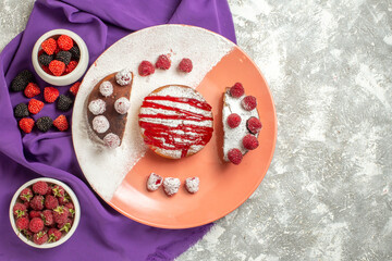 top view of plate of dessert on purple napkin with berries on side on marble background