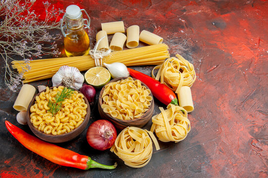 Close up view of uncooked pastas oil bottle and foods for dinner preparation on mixed color background stock image