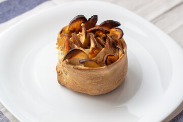 Handmade cinnamon and apple buns on a white plate.