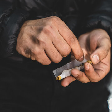 Main homme qui roule un joint de drogue beuh